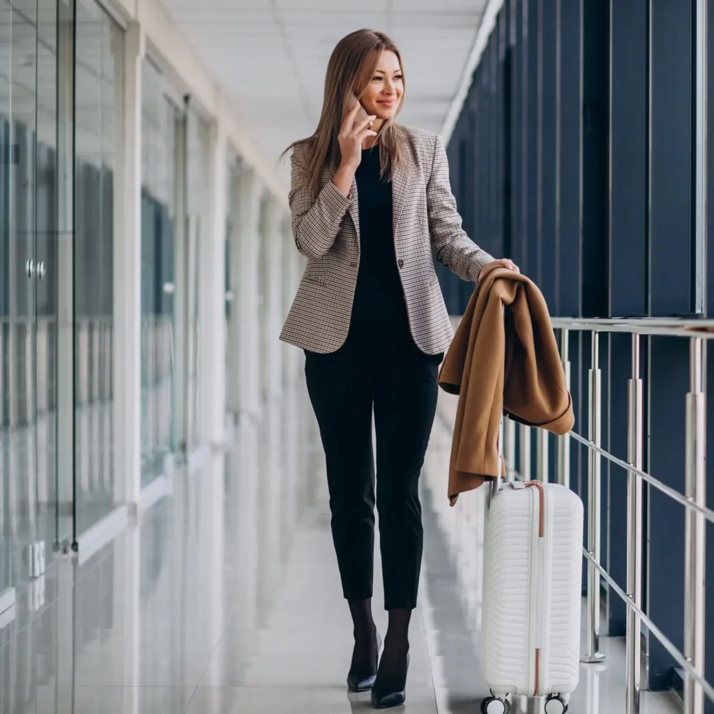 business-woman-terminal-with-travel-bag-talking-phone-min
