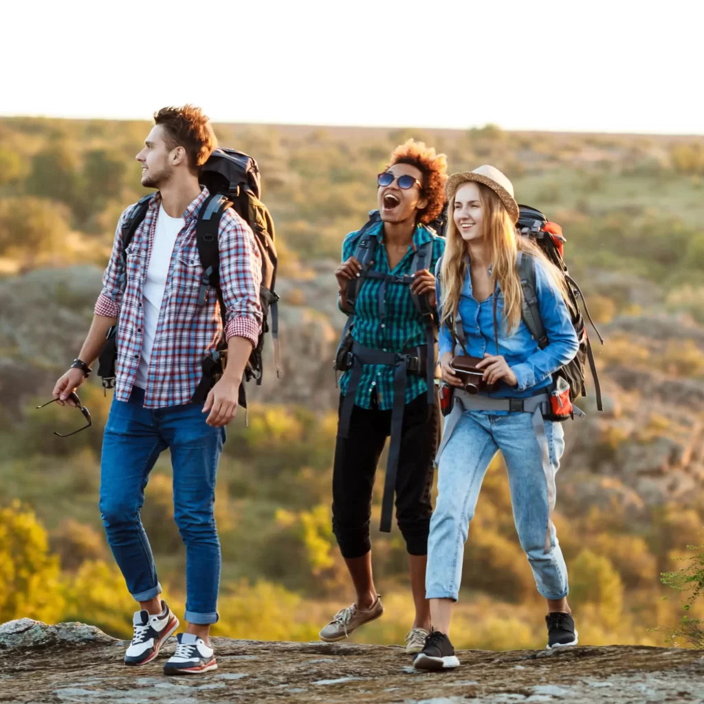 young-cheerful-travelers-with-backpacks-smiling-walking-canyon-min